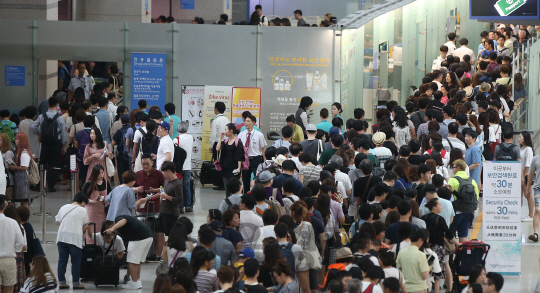 31일 오전 인천국제공항 출국장이 휴가를 떠나는 여행객들로 붐비고 있다. 공항공사에 따르면 여름 휴가철 여행객이 몰리면서 일일 여객수가 20만 명이 넘어섰다. 이는 지난 24일 18면 2천 명에서 2만 명이나 늘어난 개항 이후 최대치다./영종도=송은석기자