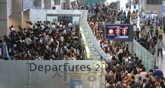 31일 오전 인천국제공항 출국장이 휴가를 떠나는 여행객들로 붐비고 있다. 공항공사에 따르면 여름 휴가철 여행객이 몰리면서 일일 여객수가 20만 명이 넘어섰다. 이는 지난 24일 18면 2천 명에서 2만 명이나 늘어난 개항 이후 최대치다./영종도=송은석기자