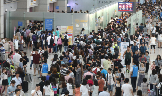 31일 오전 인천국제공항 출국장이 휴가를 떠나는 여행객들로 붐비고 있다. 공항공사에 따르면 여름 휴가철 여행객이 몰리면서 일일 여객수가 20만 명이 넘어섰다. 이는 지난 24일 18면 2천 명에서 2만 명이나 늘어난 개항 이후 최대치다./영종도=송은석기자