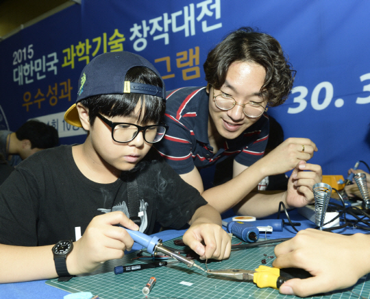 지난해 경기 고양시 킨텍스에서 열린 대한민국 과학창의축전에 참여한 학생들이 봉사자의 도움을 받아 만들기 체험을 하고 있다. 올해 열리는 대한민국과학창의축전은 오는 4~7일 서울 삼성동 코엑스에서 진행돼 참가자들은 로봇만들기 체험 프로그램 등을 할 수 있다. /연합뉴스