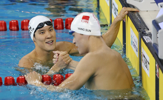 지난 2014년 9월 인천아시안게임 남자수영 자유형 400m 결선 뒤 손을 맞잡는 박태환(왼쪽)과 쑨양. 당시 각각 동메달, 금메달을 땄던 박태환과 쑨양은 2년 만에 리우데자네이루 올림픽에서 맞대결을 벌인다.  /연합뉴스