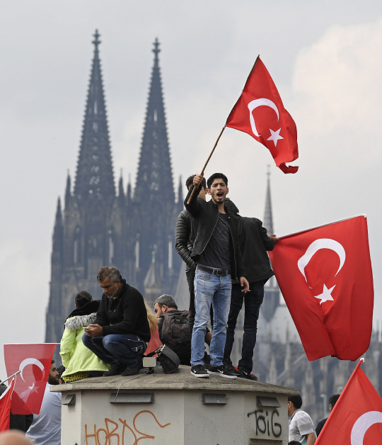 7월31일(현지시간) 독일 쾰른에서 열린 레제프 타이이프 에르도안 터키 대통령 지지 집회에 참석한 시민들이 터키 국기를 흔들고 있다. 독일 경찰 추산 약 4만명이 몰린 이번 집회의 참석자들은 대부분 터키 출신이며 이들은 군부의 쿠데타 시도를 비난하고 에르도안 정부를 지지하는 목소리를 높였다.     /쾰른=AP연합뉴스