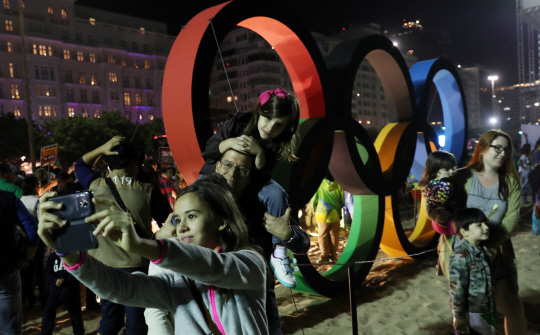 2016리우데자네이루 올림픽 개막을 하루 앞 둔 4일 밤(현지시간) 브라질 리우데자네이루 코파카바나 해변에 모인 관광객과 시민들이 올림픽 조형물 앞에서 즐거운 시간을 보내고 있다./리우=올림픽사진공동취재단