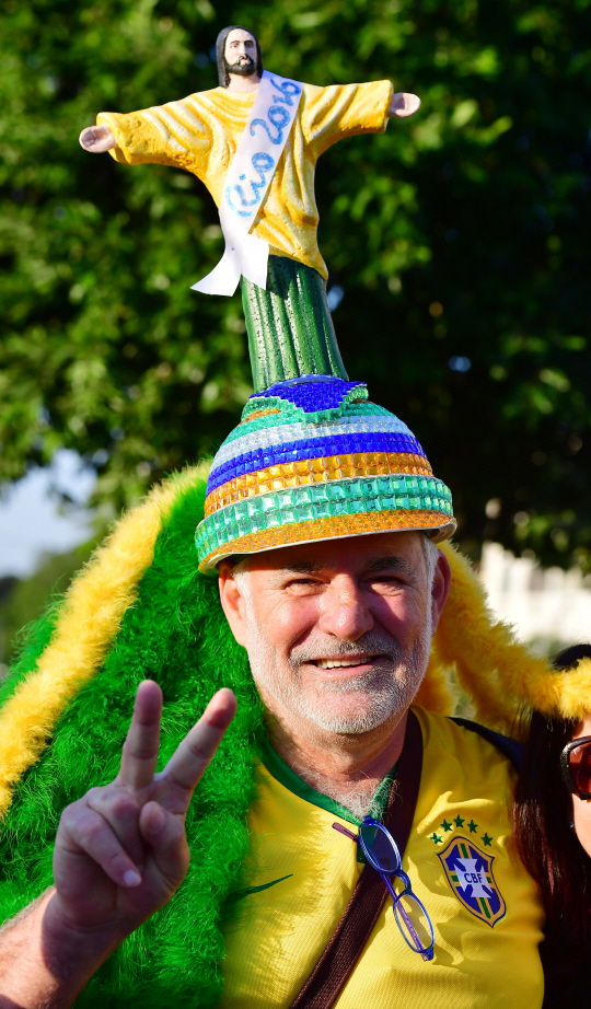 2016 리우올림픽 개막일인 5일 오후(현지시간) 개막식이 열리는 마라카낭 주경기장 앞에서 브라질 한 브라질 사람이 거대예수상 모자를 쓰고 있다. /리우데자네이루=올림픽사진공동취재단