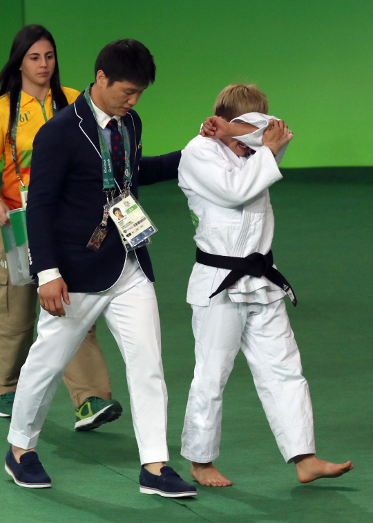 정보경 선수가 5일 오전(현지시간) 브라질 리우데자네이루 바하 올림픽파크 경기장에서 열린 유도 여자 48kg급 이하 결승전에서 아르헨티나 파울라파레토 선수에게 패해 은메달을 차지했다. 정 선수가 경기가 끝난뒤 이원희 코치의 위로를 받으며 퇴장하고 있다./리우데자네이루=올림픽사진공동취재단