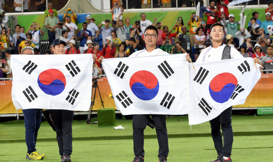 6일 (현지시각) 브라질 리우 마라카낭 삼보드로무 양궁경기장에서 열린 리우 올림픽 남자 양궁단제전 에서 대한민국 남자 양궁팀의 금매달이 확정되자 이승윤,김우진,구본찬 선수가 태극기를 들고 환호하고 있다./2016.8.6./리우데자네이루=이호재기자