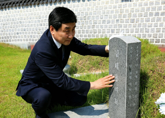 이종걸 더불어민주당 당 대표 후보가 7일 광주 국립 5·18 민주묘지를 찾아 김태홍 전 의원의 묘비를 쓰다듬고 있다.  /사진제공=더불어민주당