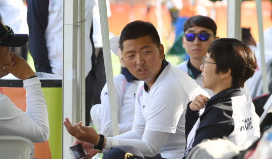 브라질 리우데자네이루 올림픽 2관왕에 도전했던 한국 양궁대표팀의 김우진(청주시청)이 남자 개인전 32강에서 충격패를 당한 8일(현지시각) 경기후 코치진들과 무거운 표정으로 이야기를 나누고 있다.
세계랭킹 1위 김우진은 9일 브라질 리우의 삼보드로무 경기장에서 열린 남자 개인전 32강에서 리아우 에가 에거사(인도네시아)에 세트점수 2-6(9-27 27-28 24-27 27-28)으로 졌다./리우데자네이루=이호재기자