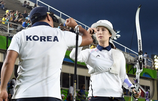 여자 양궁 기보배 선수가 8일(현지시간) 브라질 리우 마라카낭 삼보드로무 양궁경기장에서 열린 개인 16강전에서 10점에 명중 시킨뒤 양창훈 감독과 손을 잡고 있다./리우데자네이루=이호재기자