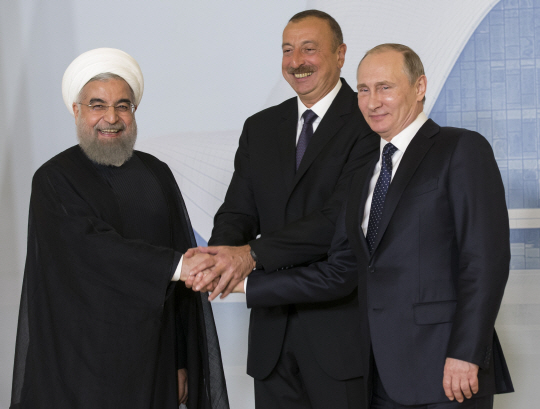 8일 아제르바이잔 바쿠에서 정상회담을 개최한 블라미디르 푸틴(사진 맨 오른쪽) 대통령, 일함 알리예프(가운데) 아제르바이잔 대통령, 하산 로하니 이란 대통령이 서로 손을 맞잡고 있다. /바쿠=AP연합뉴스