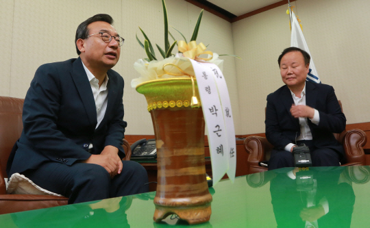 이정현 신임 새누리당 대표가 10일 오전 서울 여의도 당사 집무실에서 김재원 청와대 정무수석으로부터 박근혜 대통령의 축하 난을 전달받은 뒤 얘기를 나누고 있다. /연합뉴스