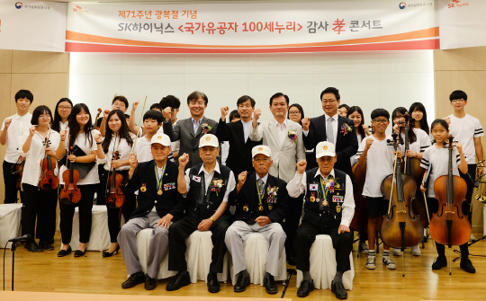 SK하이닉스의 국가유공자 대상 ‘감사 효(孝) 콘서트’에 참석한 신승국(둘째줄 왼쪽부터) SK하이닉스 대외협력본부장 전무, 김진배 행복나눔 꿈의 오케스트라 지휘자, 남창수 경기남부보훈지청장, 조영운 사랑의달팽이 사무국장이 국가유공자, 행복나눔 꿈의 오케스트라 단원들과 함께 파이팅을 외치고 있다. /사진제공=SK하이닉스