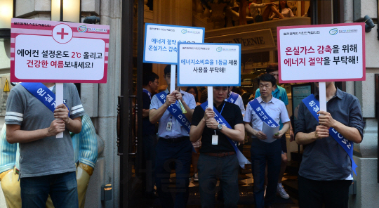 10일 서울 명동에서 중구청 및 한국에너지공단 직원들이 문을 열어둔 채 에어컨을 틀어놓은 상점에 대해 주의조치를 내리고 있다. 정부는 11일부터 문을 열고 냉방영업을 하는 업소에 과태료를 부과한다.   /송은석기자