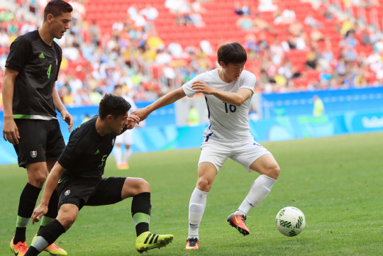 한국축구대표 권창훈이 10일 오후(현지시간) 2016년 리우올림픽 남자축구 C조 3차전 멕시코전이 열린 브라질 브라질리아 Mane Garrincha Stadium(마네 가힌샤 경기장)에서 두 명의 수비를 제치고 드리블 하고 있다./브라질리아=올림픽사진공동취재단