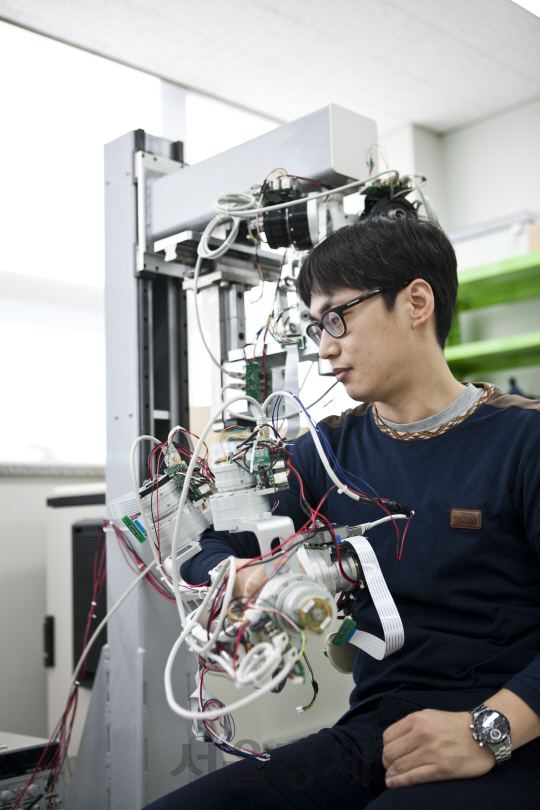 한국기계연구원에서 개발한 상지 관절별 맞춤형 재활치료 로봇을 착용, 시연하고 있다. 사진제공=한국기계연구원