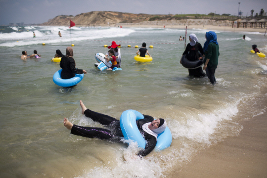 팔레스타인 자치지구인 웨스트뱅크 주민들이 8일(현지시간) 이스라엘 텔아비브 해변에서 물놀이를 즐기고 있다. 그동안 웨스트뱅크 주민들은 이스라엘 영토에 가로막혀 해변에 접근할 수 없었지만 최근 이스라엘 정부의 허가로 이번 방문이 허용됐다.      /텔아비브=EPA연합뉴스