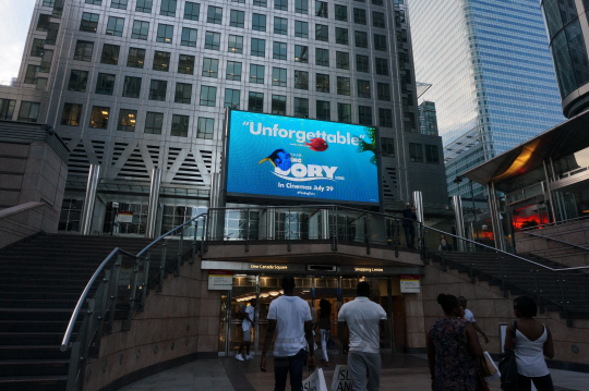 원캐나다스퀘어 지하 입구에 위에 설치된 대형 광고스크린 아래로 사람들이 지나가고 있다. 볼드마인드는 스크린 상단에 설치된 카메라를 통해 광고를 보는 사람들의 행동이나 표정까지 분석해 맞춤형 광고를 제공하고 있다./런던=조민규기자