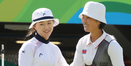 양궁대표팀 장혜진 선수가 11일 (현지시간) 브라질 리우데자네이루 마라카낭 삼보드로무 양궁장에서 열린 2016 리우올림픽 양궁 여자 개인전 16강 경기에서 북한 강은주와 대결을 펼친후 인사를 나누고 있다./리우데자네이루=올림픽사진공동취재단