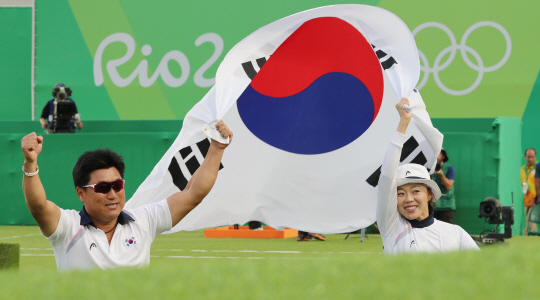 양궁대표팀 장혜진 선수가 11일 (현지시간) 브라질 리우데자네이루 마라카낭 삼보드로무 양궁장에서 열린 2016 리우올림픽 양궁 여자 개인전에서 금메달을 획득한뒤 양창훈감독과 태극기 세레머니를 하고 있다./리우데자네이루=올림픽사진공동취재단