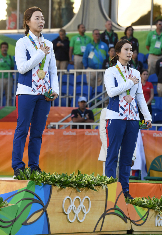 여자양궁 대표팀 장혜진이 11일 오후(현지시간) 브라질 리우데자네이루 마라카낭 삼보드로무 양궁장에서 열린 2016 리우 올림픽 양궁 여자 개인전 결승에서 승리하며 금메달을 획득했다. 금메달 장혜진과 동메달을 따낸 기보배가 국민의례를 하고 있다. /리우데자네이루=올림픽사진공동취재단