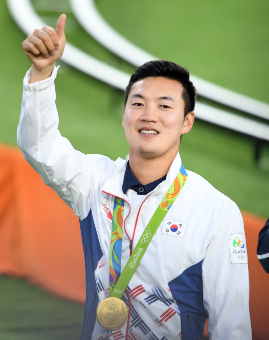 남자양궁 구본찬이 12일 오후(현지시간) 브라질 리우데자네이루 마라카낭 삼보드로무 양궁장에서 열린 2016 리우 올림픽 양궁 남자 개인전 금메달을 목에 건 후 환호하고 있다./리우데자네이루=올림픽사진공동취재단