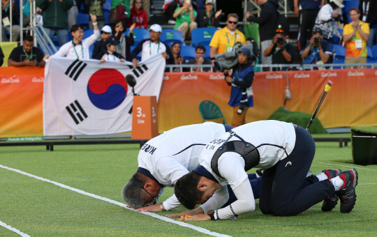 12일 오후(현지시간) 리우데자네이루 마라카낭 삼보드로무에서 열린 남자 양궁 개인전에서 구본찬이 금메달을 목에 걸었다.  구본찬이 박채순 감독과 절을 하고 있다./리우데자네이루=올림픽사진공동취재단