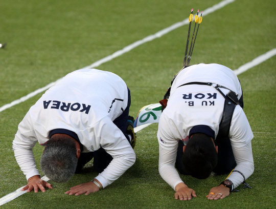 남자양궁 구본찬이 12일 오후(현지시간) 브라질 리우데자네이루 마라카낭 삼보드로무 양궁장에서 열린 2016 리우 올림픽 양궁 남자 개인전 결승에서 금메달을 확정지은 뒤 박채순 감독과 함께 관중을 향해 절을 하고 있다./리우데자네이루=올림픽사진공동취재단