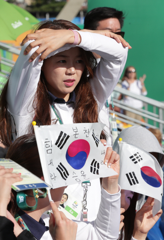 여자양궁 금메달리스트 장혜진이 12일 오후(현지시간) 브라질 리우데자네이루 마라카낭 삼보드로무 양궁장에서 열린 2016 리우 올림픽 양궁 남자 개인전에 응원 와 강한 햇빛을 손으로 가린 채 응원하고 있다./리우데자네이루=올림픽사진공동취재단