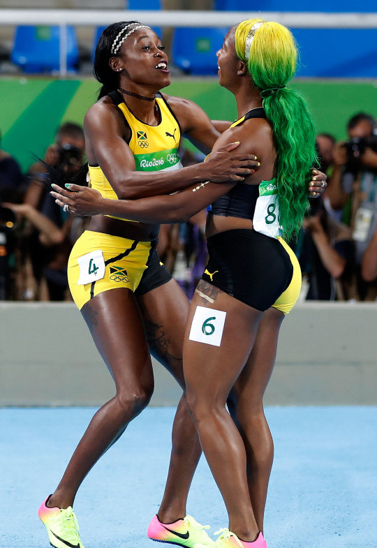“내가 100m 퀸.” 일레인 톰프슨(왼쪽)이 14일(한국시간) 육상 여자 100m 결선에서 1위를 차지한 뒤 올림픽 3연패에 도전했던 자메이카 대표팀 선배 프레이저 프라이스와 포옹하며 활짝 웃고 있다. /리우데자네이루=신화연합뉴스