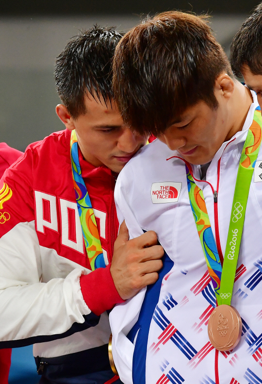 14일 오후(현지시간) 브라질 바하 리우데자네이루의 카리오카 아레나 2에서 열린 '2016 리우 올림픽' 남자 레슬링 그레코로만형 75kg급 시상식에서 석연찮은 판정으로 금메달을 차지한 러시아에 로만 블라소프가 동메달을 차지한 김현우에게 미안한듯한 행동을 보이고 있다./리우데자네이루=올림픽사진공동취재단