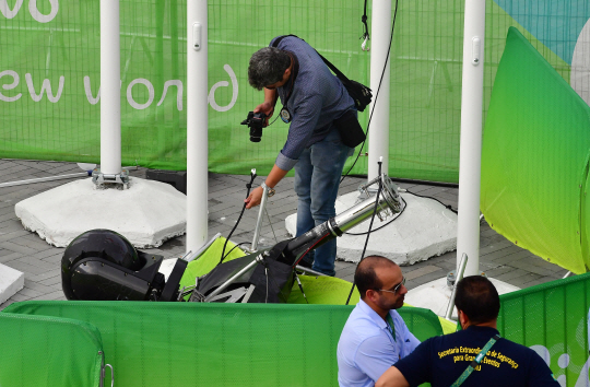 15일(현지시간) 브라질 리우데자네이루 바하 올림픽파크에서 중계카메라를 매단 케이블이 카메라와 함께 바닥으로 떨어져 경기장에 입장하던 여성 2명이 부상당하는 사고가 발생했다. 사진은 관계자가 카메라를 조사하는 모습. 2016.8.15/리우데자네이루=올림픽사진공동취재단