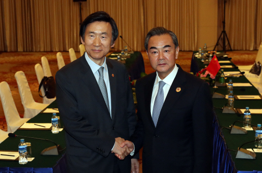 윤병세 외교장관이 지난 7월25일 오전(한국시간) 라오스 비엔티안 국립컨벤션센터(NCC)에서 열린 중국과의 양자회담에서 왕이 외교부장과 악수를 하고 있다. /비엔티안=연합뉴스