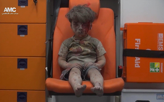 공습으로 무너진 시리아 알레포의 한 건물에서 구출된 어린아이가 피와 먼지로 범벅이 된 채 구급차 의자에 앉아 멍한 얼굴로 허공을 바라보고 있다. 시리아 반군 매체 알레포미디어센터(AMC)가 17일(현지시간) 공개한 다섯 살 난 시리아 남자아이의 이 사진과 영상은 소셜네트워크서비스(SNS)를 통해 전 세계로 퍼지며 내전으로 고통받는 시리아인들의 아픔을 고스란히 전달하고 있다.  　 /알레포=AP연합뉴스