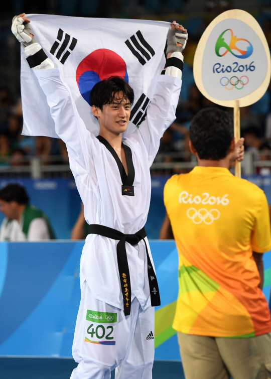 태권도 국가대표 이대훈 선수가 18일 오후(현지시간) 브라질 리우데자네이루 바하 올림픽파크 카리오카 아레나3에서 열린 2016 브라질 리우올림픽 태권도 남자 68kg급 동메달결정전에서 벨기에의 자우드 아찹과의 경기에서 승리하며 동메달을 획득했다. 태극기를 들고 환하게 웃는 이대훈.  /리우데자네이루=올림픽사진공동취재단