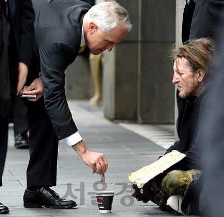노숙자에게 돈을 주고 있는 멜컴 턴불(왼쪽) 호주 총리/EPA연합뉴스