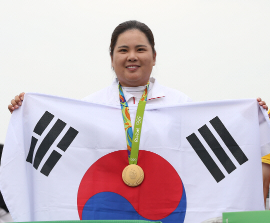 박인비가 20일 오후(현지시간) 브라질 리우데자네이루 올림픽 골프경기장에서 열린 여자 골프 4라운드 경기에서 금메달을 차지했다. 금메달을 목에 건 박인비가 태극기를 들어보이고 있다./리우데자네이루=올림픽사진공동취재단