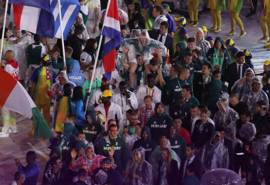21일(현지시간) 브라질 리우데자네이루 마라카낭 주경기장에서 열린 2016리우올림픽 폐회식에서 선수들이 우비를 입고 경기장에 들어서고 있다./출처=연합뉴스
