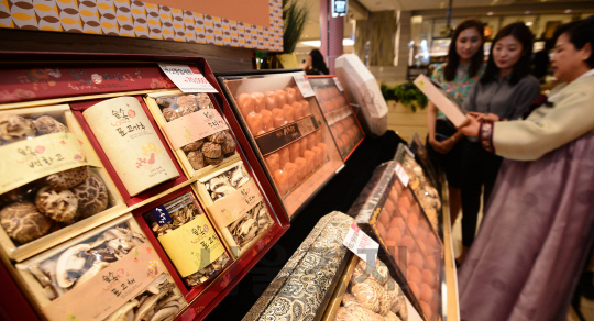 민족 최대의 명절인 추석을 앞두고 선물 판매가 시작된 22일 오전 서울 롯데백화점 본점에서 고객들이 추석 선물 세트로 마련된 과일들을 살펴보고 있다./송은석기자