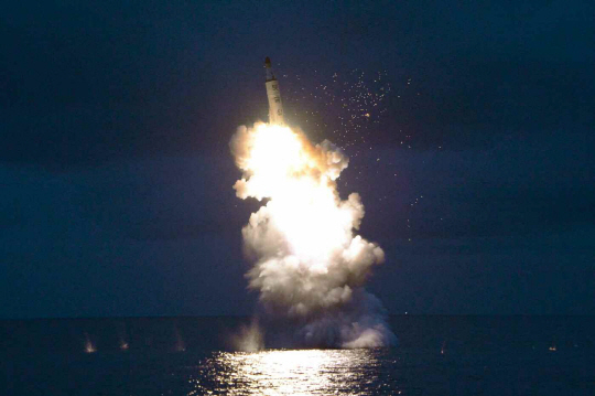 북한 조선중앙TV는 25일 낮12시30분 전날 실시한 잠수함발사탄도미사일(SLBM) 시험발사 장면을 담은 사진을 공개했다. SLBM 발사 모습(사진 아래)과 발사 성공에 기뻐하는 김정은(사진 위).  /연합뉴스