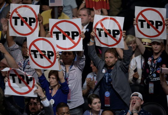지난 달 25일(현지시간) 미국 펜실베이니아주 필라델피아에서 열린 민주당 전당대회(DNC)에서 당원들이 환태평양경제동반자협정(TPP)에 반대한다는 기호가 적힌 종이를 들고 서 있다. /필라델피아=AFP연합뉴스