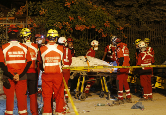 26일(현지시간) 이탈리아 중부도시 아마트리체에서 구조대원들이 지진 피해 사망자의 시신을 옮기고 있다./AP연합뉴스