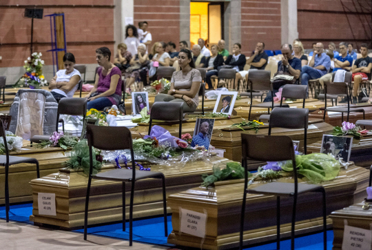 26일(현지시간) 이탈리아 중부 도시 아스콜리 피체노에서 장례식을 앞둔 지진 피해 사망자들의 관이 체육관으로 옮겨져 있다./로이터연합뉴스