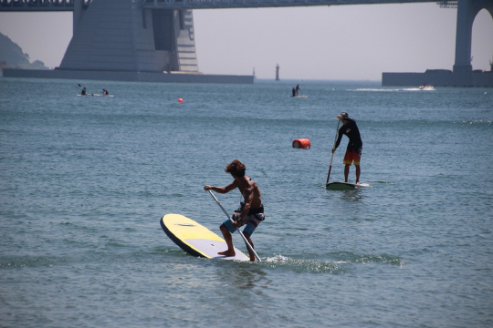 최근 인기를 끌고 있는 SUP(Stand Up Paddle Board)을 즐길 수 있는 아카데미가 부산 광안리해수욕장 앞바다에서 운영된다./사진제공=수영구