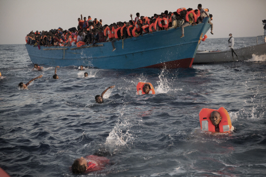 29일(현지시간) 리비아 북부 해상에서 바다에 뛰어든 난민들이 구조대를 향해 헤엄치고 있다. 이들은 구조선에서 이탈리아 해안경비대로 옮겨진 뒤 이탈리아 시칠리아에 도착했다./사브라타=AP연합뉴스