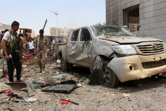 29일(현지시간) 차량폭탄테러가 일어난 예멘 남부 아덴시에서 시민들이 폭발로 인해 손상된 차량을 바라보고 있다. 이슬람 극단주의 무장단체 ‘이슬람국가(IS)’는 이번 테러의 배후를 자처했다. /아덴=AFP연합뉴스