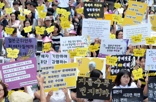 지난 10일 오후 서울 종로구 옛 일본대사관 앞에서 열린 ‘제4차 세계 일본군 위안부 기림일 세계연대집회 및 1243차 일본군 위안부 문제 해결을 위한 정기 수요집회’ 참석자들이 평화의 팻말을 들고 있다. /연합뉴스