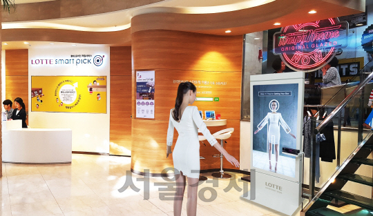 롯데백화점 모델이 서울 명동 본점 지하 1층에서 3D 가상 피팅 서비스를 체험해 보고 있다. /사진제공=롯데백화점