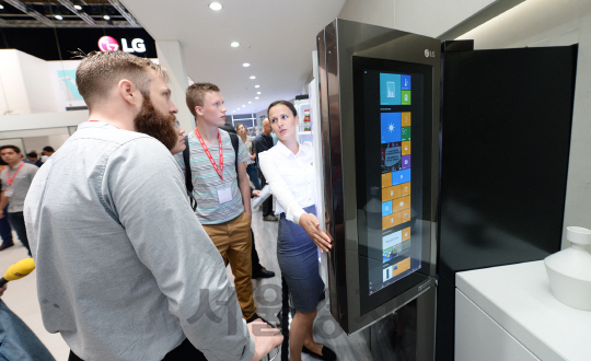 5일(현지시각) 독일 베를린에서 열리고 있는 유럽 최대 가전전시회 IFA 2016에서 관람객들이 LG전자 스마트 냉장고를 살펴보고 있다. LG전자는 이번 전시회에서 역대 최대 규모인 5,220제곱미터(㎡)의 부스를 마련하고 초프리미엄 가전 ‘LG 시그니처’와 올레드 TV, 유럽 공략을 위한 고효율 프리미엄 가전, 더 편리해진 스마트 가전, 생활가전의 핵심부품인 모터와 컴프레서 등을 소개했다./사진제공=LG전자