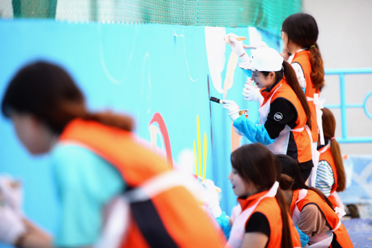 미래에셋박현주재단의 장학생들이 지난 3일 서울 은평구 꿈나무마을의 수영장에 벽화를 그리고 있다. /사진제공=미래에셋