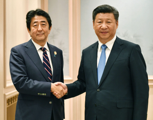 아베 신조 일본 총리(왼쪽)와 시진핑 중국 국가 주석이 5일 밤 중국 항저우에서 정상회담을 시작하기에 앞서 악수하고 있다. /연합뉴스